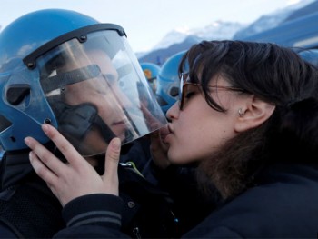 mujer besa el casco de policía